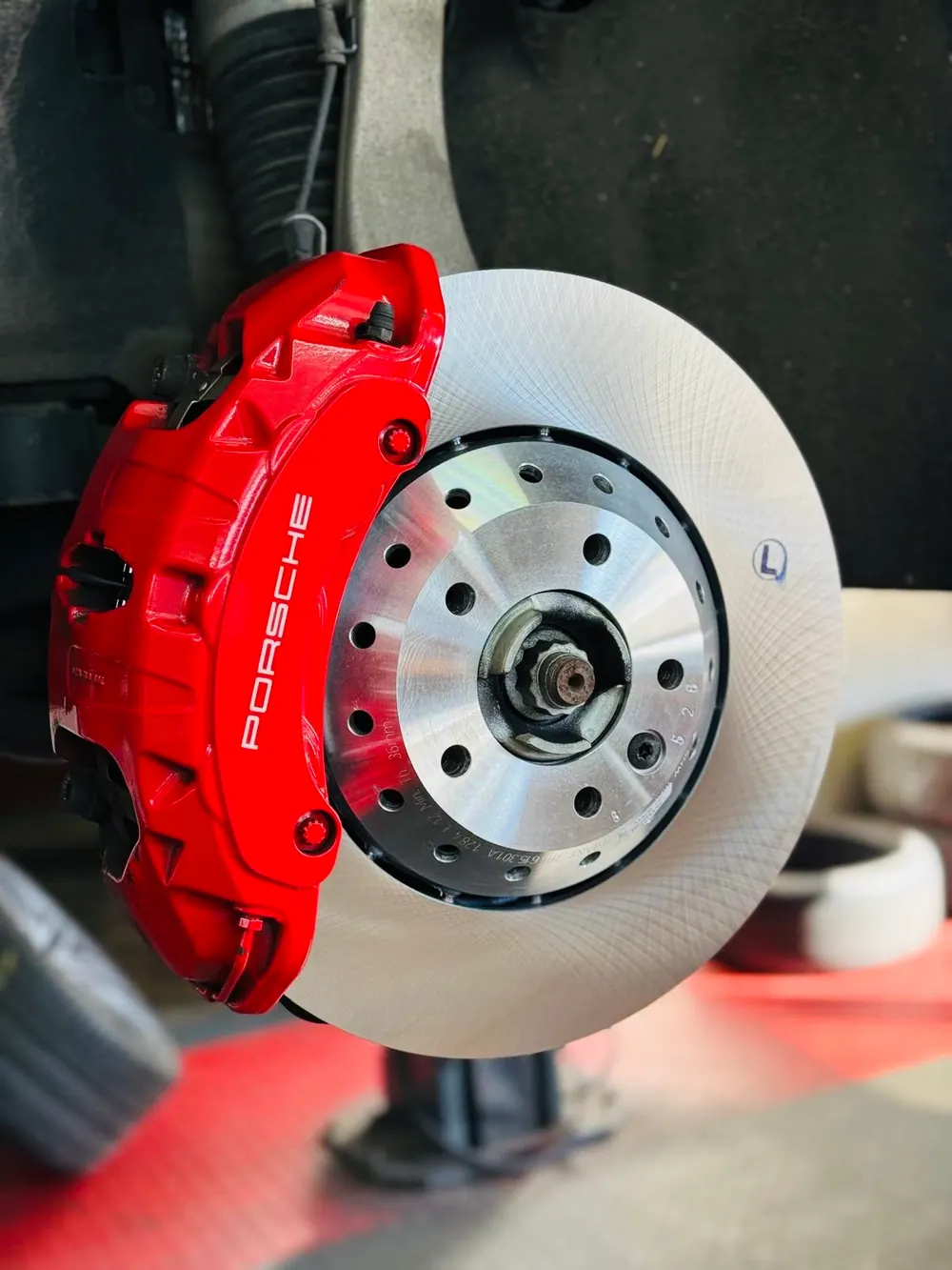Rot lackierter Bremssattel an einer gelochten Bremsscheibe